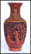 A 20th century Chinese red lacquer on brass vase decorated with foliate design.