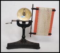 A Victorian cast iron and brass lace making machine, with decorative tripod base.