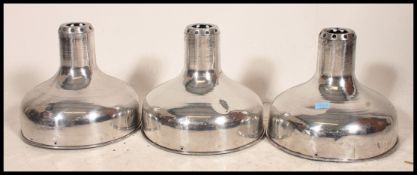 A set of 3 polished steel 20th century Industrial pendant shades.