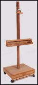 A 20th century artisits easel stand raised on plinth base with castors.