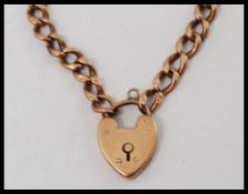 A 9ct gold ladies kerb linked small bracelet / chain with heart shaped padlock. Total weight 4.
