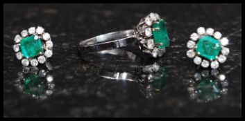 An 18ct white gold, emerald and diamond ring and earring set.