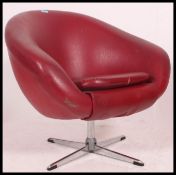 A 1970's red vinyl upholstered and chrome swivel egg chair.
