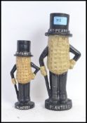 Two cast iron ' Mr Peanut ' money boxes - both of varying sizes.