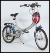 A Raleight Kompact folding bicycle in silver with rack, bell,