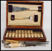A cased Edwardian mahogany canteen of cutlery with fish knives together with a horn carving set