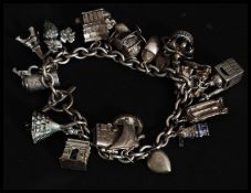 A silver 800 marked continental charm bracelet adorned with 20+ charms to include dancer, grapes,