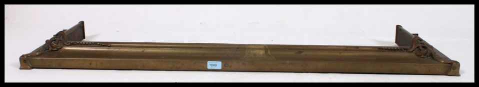 An early 20th century / Victorian brass fire fender in the arts and crafts style measuring.
