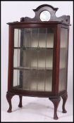 An Edwardian mahogany leaded and coloured glass bow front display cabinet.