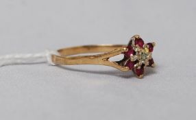 A 9ct gold diamond and ruby garnet stone flower ring.