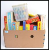 A box of assorted vintage games and jigsaw puzzles to include Tiddley Winks, Pick Up Sticks,