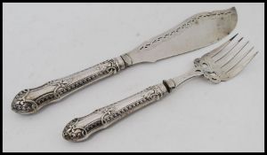 A pair of large silver handled fish servers.