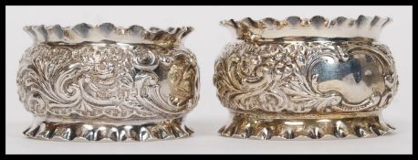 A pair of cased Edwardian silver hallmarked napkin rings in rococo form being stamped for
