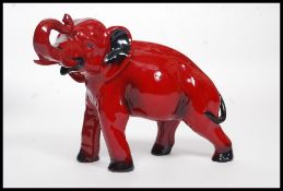 A Royal Doulton Flambe figure of an elephant, bold black and red colouring,