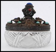 A white metal filigree worked cut glass ladies powder pot.