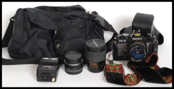 A cased Yashica FX3 SUPER 35mm SLR Film Camera along with a 28mm Yashica lens, a 135mm Yashica lens,