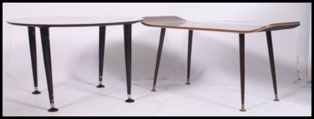 A 1970's retro teak wood coffee - occasional table in the surfboard style raised on ebonised
