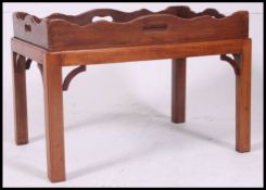 A  19th century mahogany butlers tray with gallery sides and pierced handles set  on a later  low