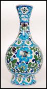 A 19th century Middle Eastern painted terracotta vase having a  floral design 44cm tall.