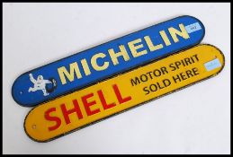 A Michelin cast iron wall sign together with a Shell Oil cast iron wall sign.