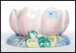 A Clarice Cliff bowl formed as a water lily decorated in pastel shades with pink leaves and blue
