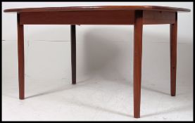 A 1970's retro G-Plan teak wood extending dining table raised on turned tapered legs with extending