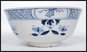An 18th century blue and white Delft bowl with flower head decoration and geometric border 1765