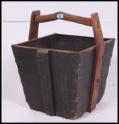 A vintage style large wooden trug of square tapering form having handle atop.