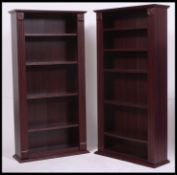 A pair of faux rosewood veneer upright open window bookcase cabinets.