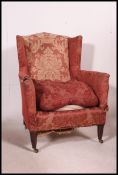 An early Victorian Wingback chenille upholstered chesterfield armchair being raised on thin,