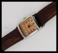 An Emporio Armani ladies dress watch with square face, caramel dial set to a leather strap.