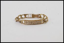 A 9ct gold kerb linked bracelet / bangle with bar being inset with low point stones approx 20 being