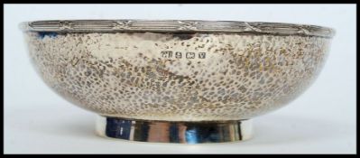 A silver hallmarked hand beaten arts and crafts style bowl having a Birmingham assay mark dated for
