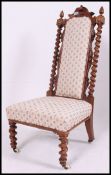 A Victorian 19th walnut barley twist nursing chair being raised on barley twist supports with white