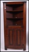 A carved oak 20th century Jaycee style corner cabinet with cupboard to base and open shelves atop.