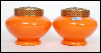 A pair of mid 20th century matching vases both in orange coloured glass and brass lattice frogs.