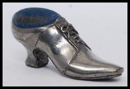 A silver plated pin cushion in the form of a shoe with baize upper.