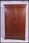 A 19th century French chestnut armoire wardrobe being raised on bracket feet with twin doors having