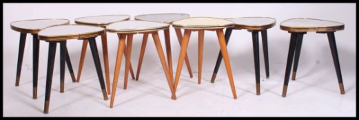 A fabulous set of 8 retro 1950's tripod tables.