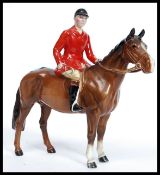 A Beswick ceramic figurine of a huntsman on a bay horse bearing Beswick England stamp to underside.