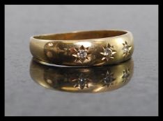 A 9ct gold and diamond 3 stone inset gypsy band ring.