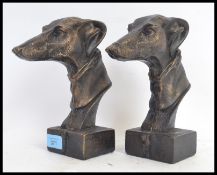 A pair of 20th century bronze effect metal statues of greyhound dogs - each on a squared metal base.
