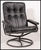 A 1970's retro black leather Danish influence swivel armchair.