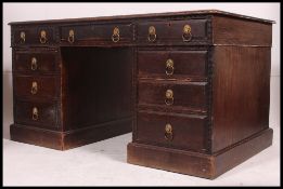 A Victorian Jacobean revival carved oak twin pedestal partners desk.
