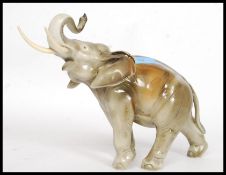 A Royal Dux china figurine of an elephant, with tusks.
