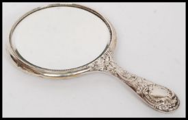 A silver hallmarked hand mirror in repousse stamped for Birmingham 1911 by Henry Matthews.