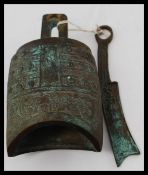 An unusual Chinese cast bronze bell with striker.