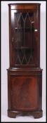 A Regency style mahogany inlaid corner cabinet with cupboard under astragal glazed cabinet atop.