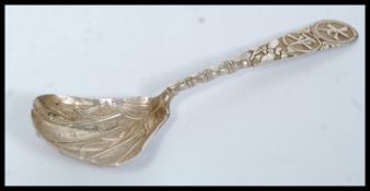 A Chinese silver caddy spoon having decorative shaped bowl with character marks to the handle.