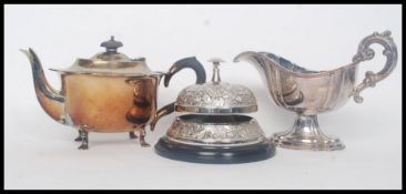 A decorative 20th century large silver plate reception bell on wooden plinth in working order.